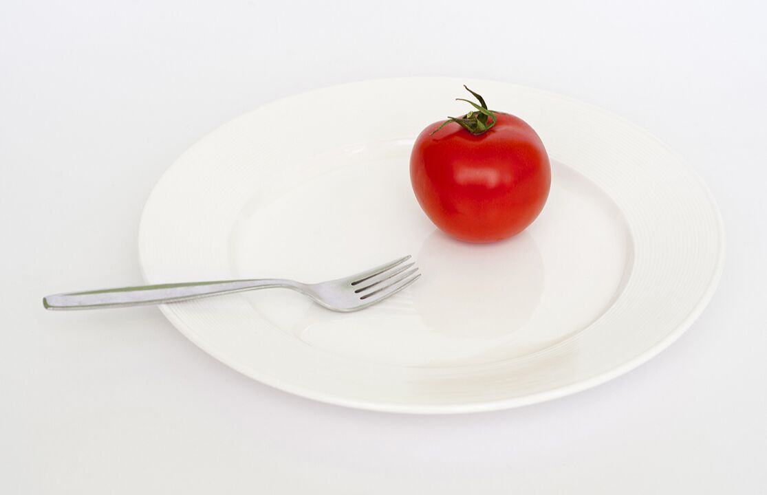 pomidoras su šakute lėkštėje
